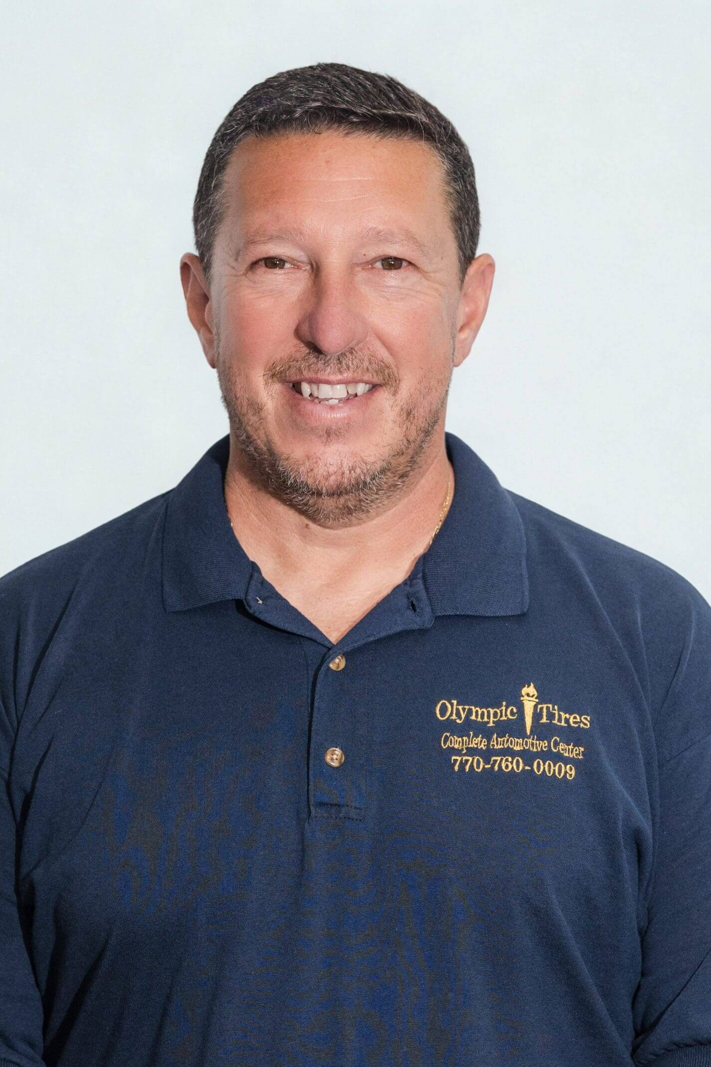 Man in a blue polo shirt smiling at the camera.