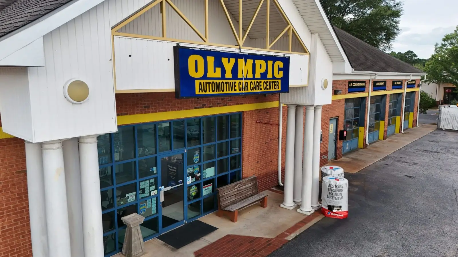 Entrance to Olympic Automotive Care Center with blue and yellow signage.